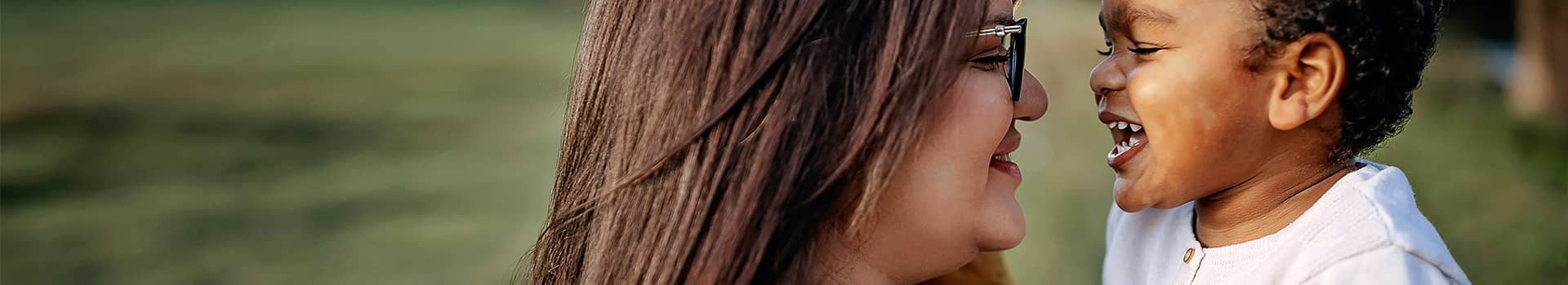 Parent and child smiling at each other. 