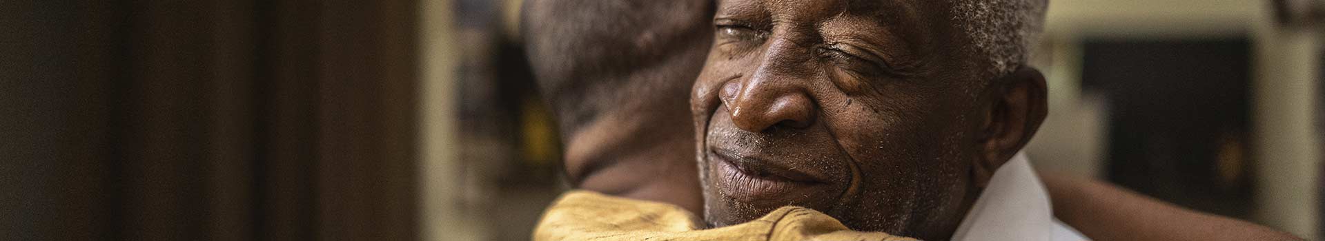 Man with comforting smile hugging a person