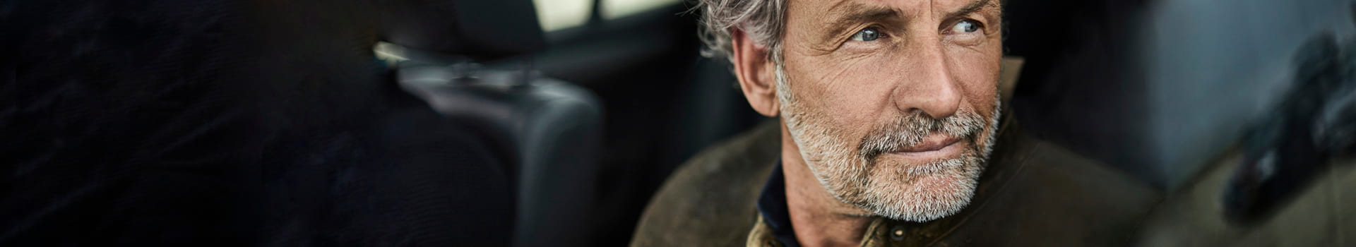 Man sitting in car looking out driver's side