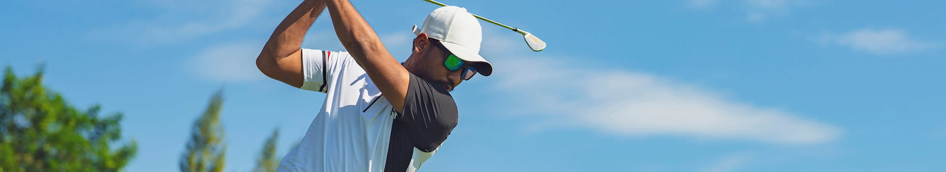 Person swinging a golf club.
