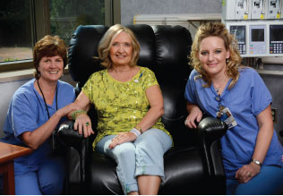 Carol Lively sits between Julie Lubahn (left), a registered nurse and certified oncology nurse, and Marianne Florin, also a registered nurse, during her 90th chemo treatment.