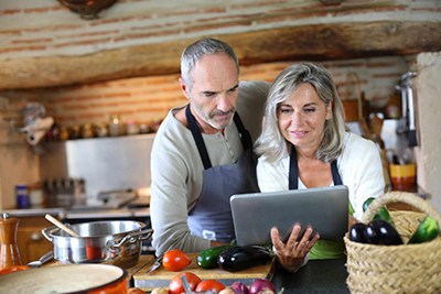 Couple in Kitchen Looking at Tablet