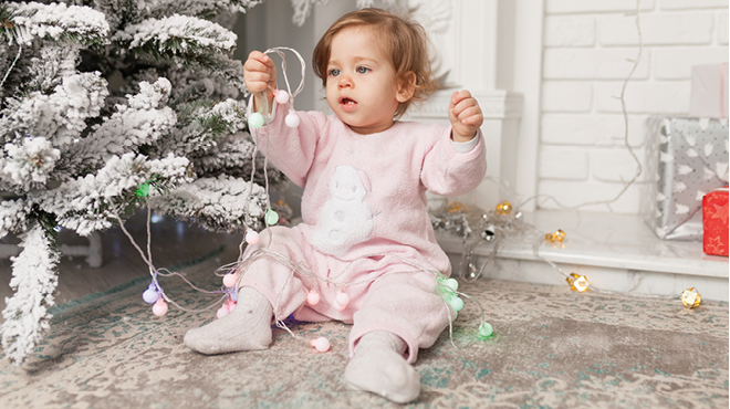Baby playing with Christmas lights