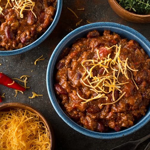 Chili in a bowl with shredded cheese on top