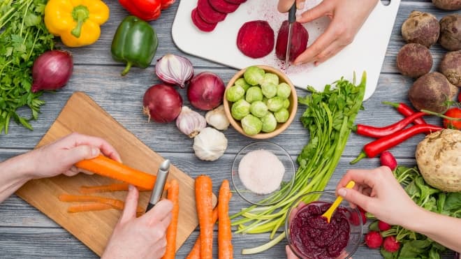 Hands preparing variety of vegetables