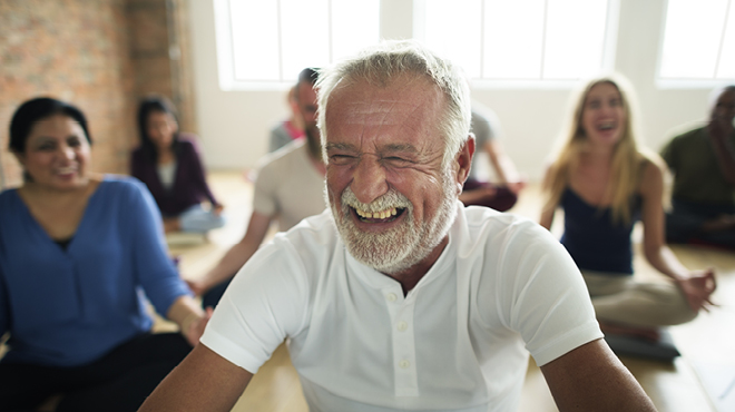 Mature man laughing during meditation class
