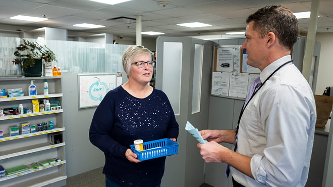 Pharmacist and patient with prescription