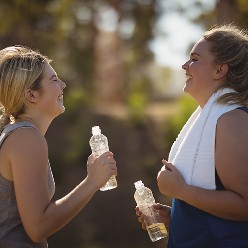 Two women with water bottles after working out