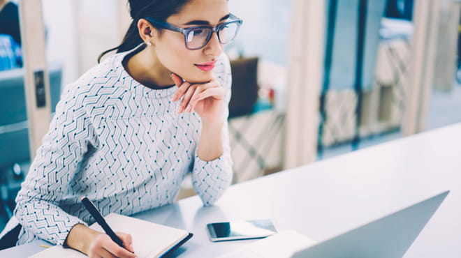 Young woman thinking and writing