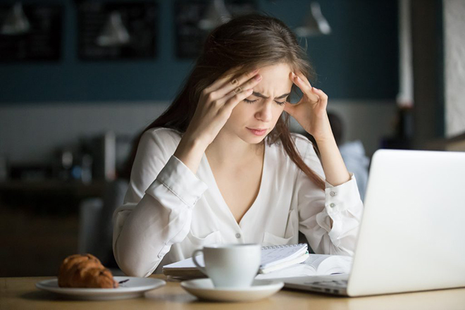 woman-overwhelmed-with-hands-on-head-sitting-in-front-of-computer