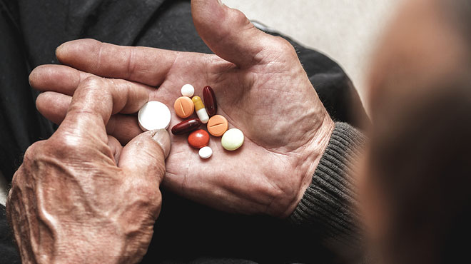 Elderly palm of hand holding medications