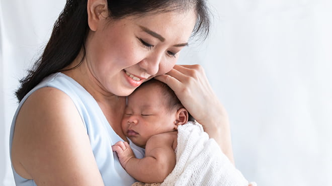 New mom cuddling newborn baby