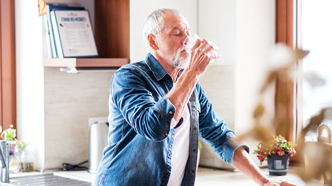 Older man drinking glass of water