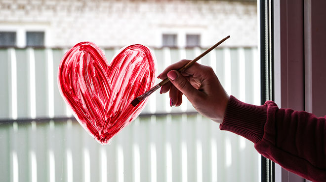 Painting red heart on window