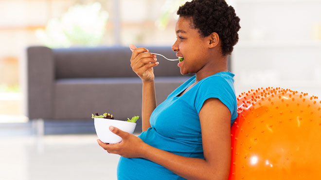 Pregnant woman eating salad