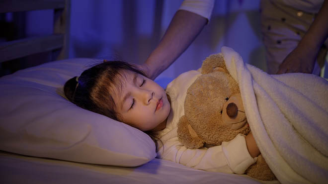 Child sleeping with teddy bear