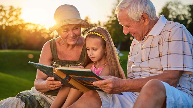Grandparents reading book wtih granddaughter