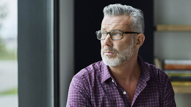 Grey haired person wearing glasses and looking to side
