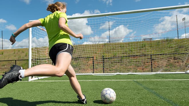 Kicking soccer ball into net