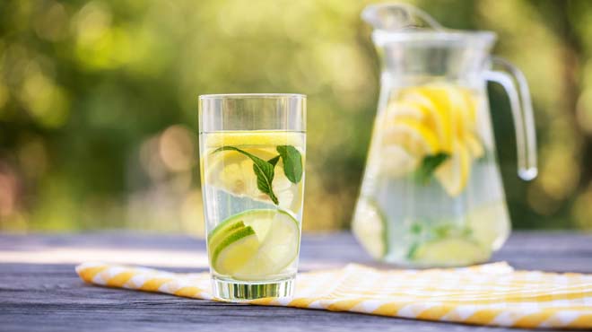 Lemons and limes in water glass
