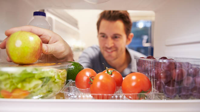 Looking inside refrigerator with fruits and lettuce
