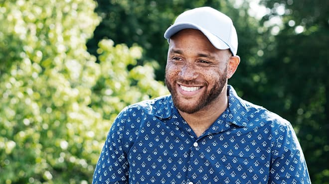 Smiling person wearing a blue shirt and white hat