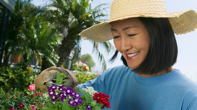 Smiling person with hat flower gardening