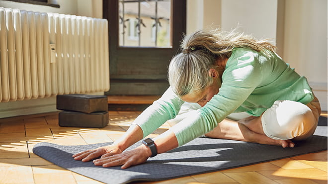 Stretching while sitting on yoga mat