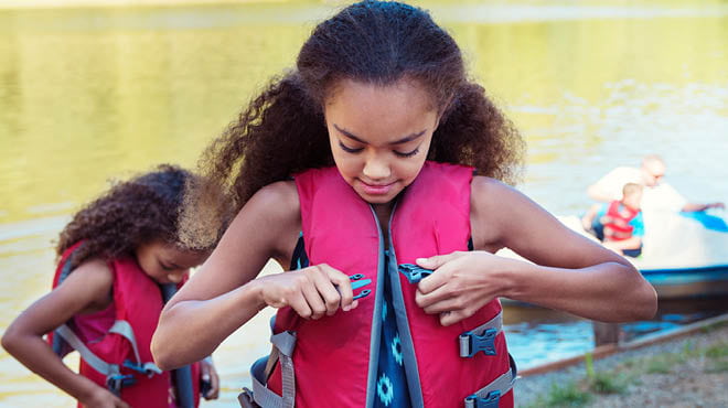 Two kids fastening life jackets