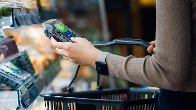 Shopping for blueberries in package at grocery store