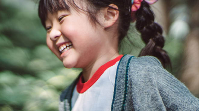 Child with a braided ponytail smiling