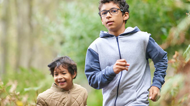 Children running in wooded area