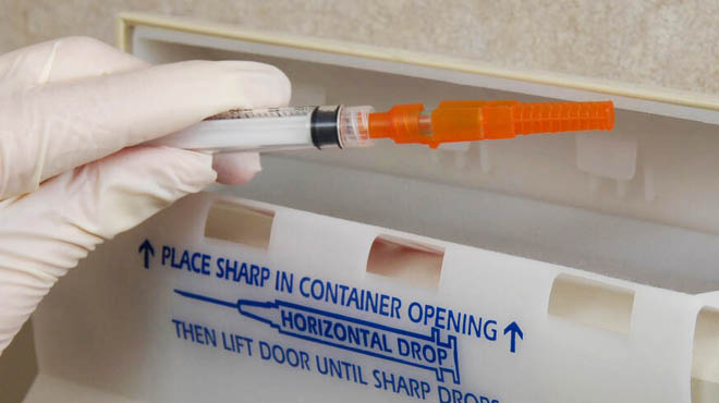 Dsiposing syringe in sharps container