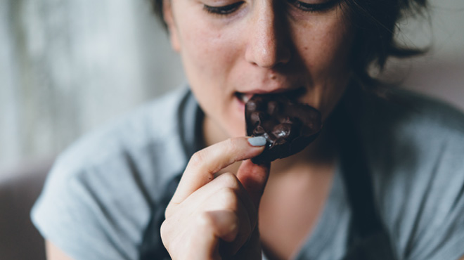 Eating heart shaped dark chocolate