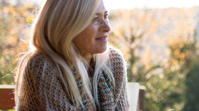 Person with long blonde hair wearing knit sweater