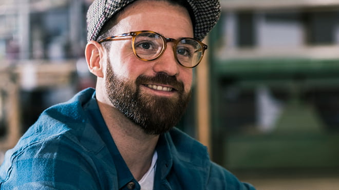 Person with tweed hat wearing glasses
