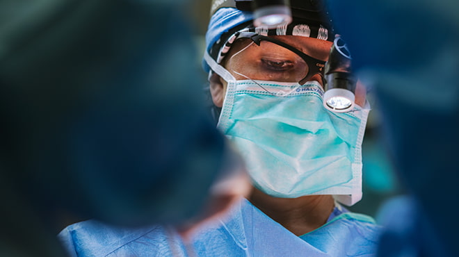 Surgeon masked and wearing surgical glasses