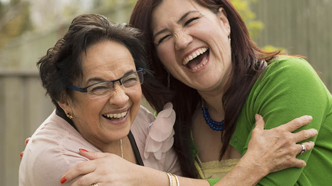 Two people side hugging and laughing Two people side hugging and laughing