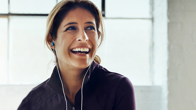 Using earbuds and smiling