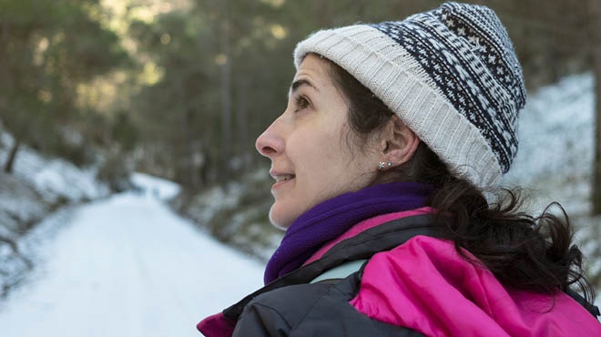 Person walking on winter trail, wearing knit hat