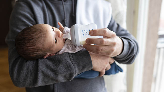 Bottle-feeding baby in arms