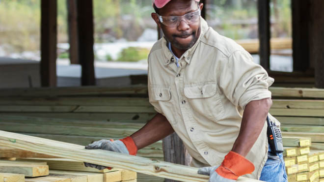 Person holding 2x4 and wearing safety glasses