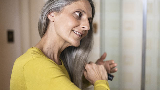 Person brushing long grey hair