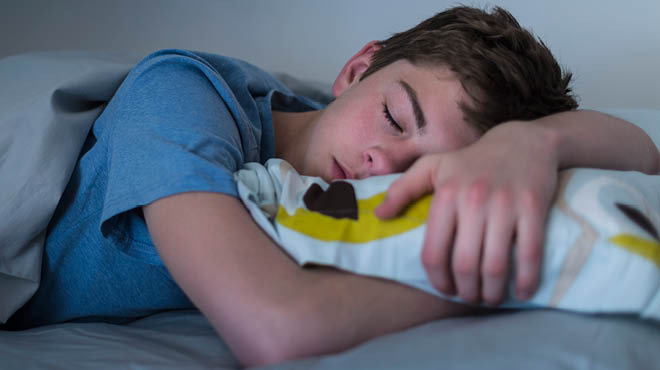 Preteen sleeping arms crossed on pillow