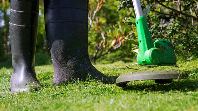 Weedeating wearing rubber boots
