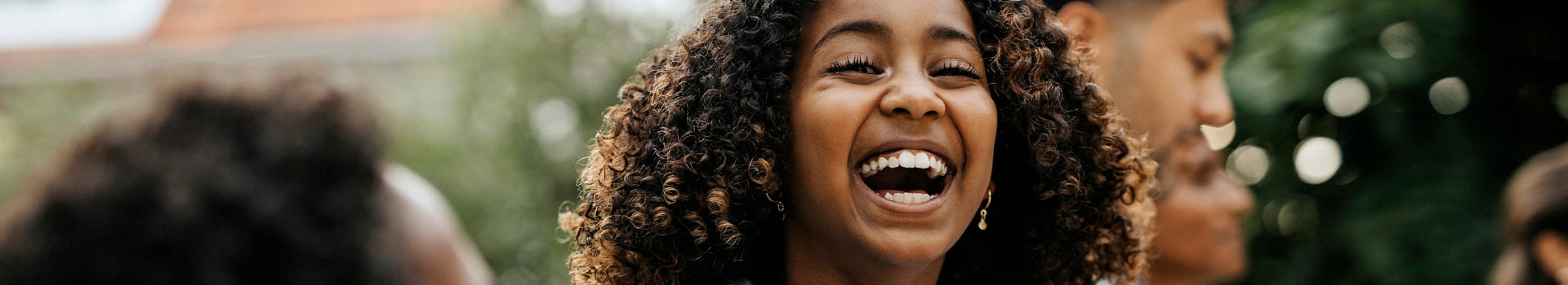 Person wearing a grey sweater and laughing.