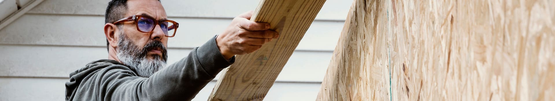 Person holding lumber.