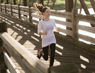 Woman running on foot bridge